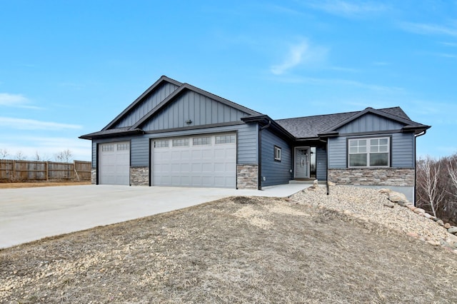 view of front of house with board and batten siding, fence, concrete driveway, stone siding, and an attached garage