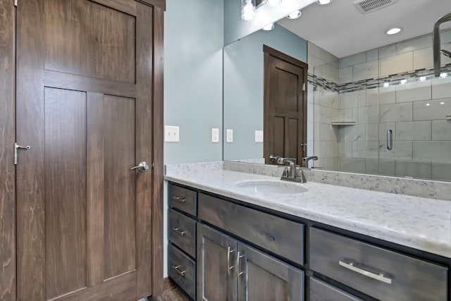 full bathroom featuring visible vents, a stall shower, and vanity