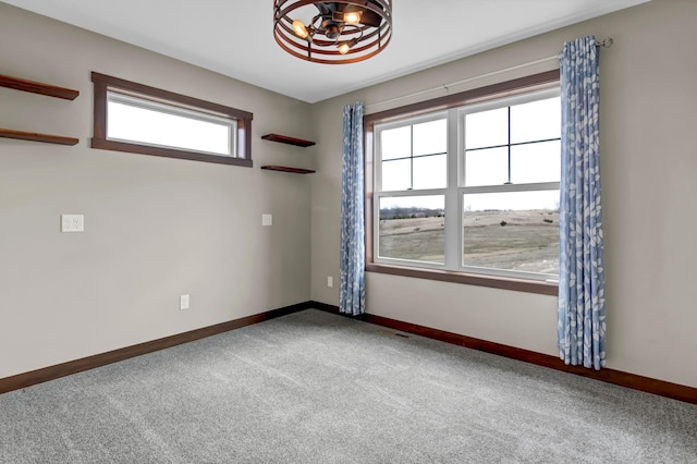 unfurnished room featuring carpet and baseboards