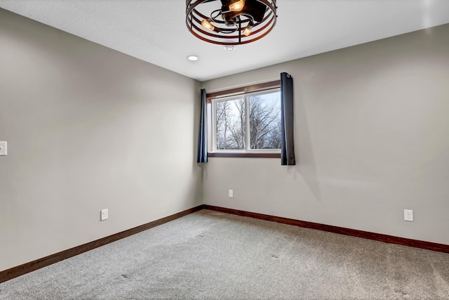 empty room featuring baseboards and carpet