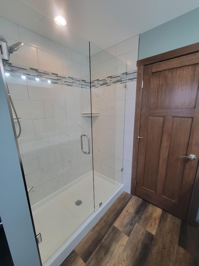 full bathroom featuring a stall shower and wood finished floors
