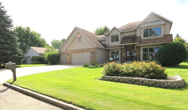 view of front of home with a garage, driveway, a front yard, and stone siding