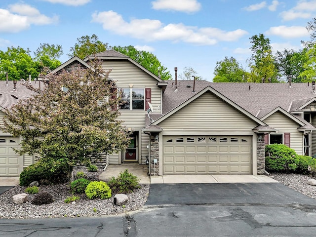 29561 Mentzer Ct, Lindstrom, MN 55045 - view of front of house with stone siding, an attached garage, driveway, and a shingled roof