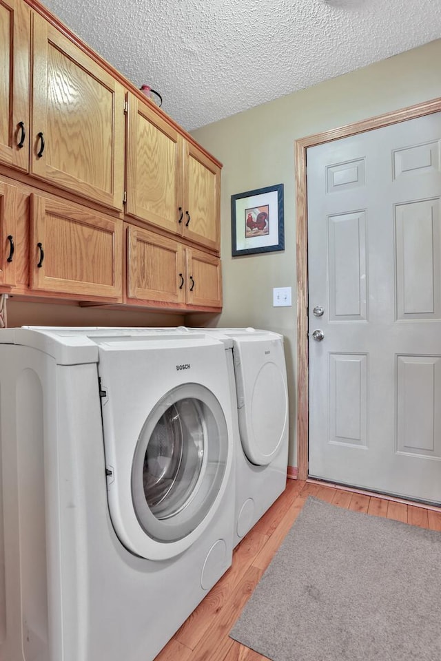 29561 Mentzer Ct, Lindstrom, MN 55045 - laundry room with cabinet space, washing machine and dryer, light wood-type flooring, and a textured ceiling