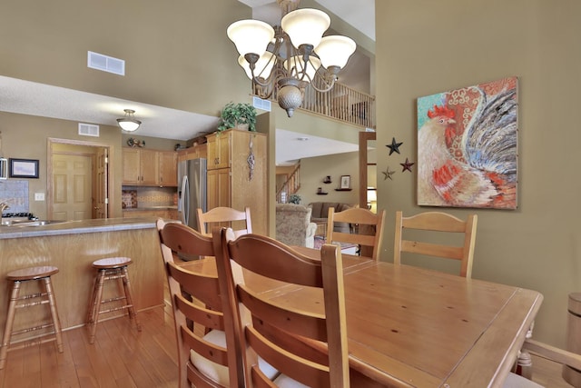 29561 Mentzer Ct, Lindstrom, MN 55045 - dining room featuring a towering ceiling, light wood-style floors, and a chandelier