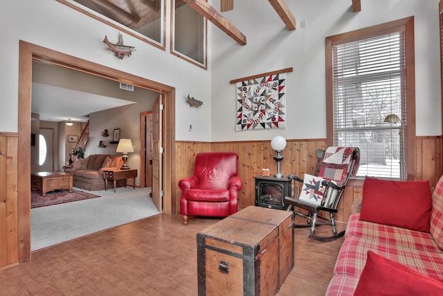 29561 Mentzer Ct, Lindstrom, MN 55045 - living room with wainscoting, a wood stove, wood walls, wood finished floors, and plenty of natural light