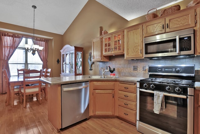 29561 Mentzer Ct, Lindstrom, MN 55045 - kitchen featuring stainless steel appliances, a sink, a chandelier, a peninsula, and lofted ceiling