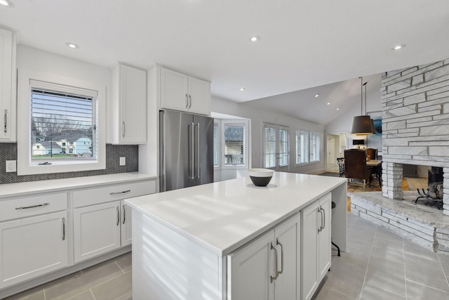 kitchen with decorative backsplash, light countertops, high end fridge, and white cabinetry
