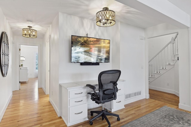 office area featuring visible vents, baseboards, a notable chandelier, and light wood-style flooring