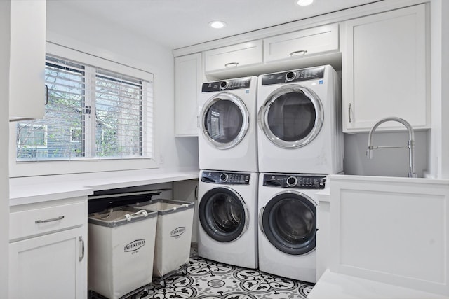 laundry area with independent washer and dryer, cabinet space, stacked washer / drying machine, and a sink