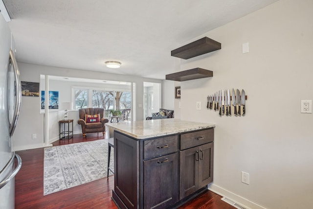 16139 Northwood Rd NW, Prior Lake, MN 55372 - kitchen with dark wood-style floors, freestanding refrigerator, a breakfast bar, baseboards, and dark brown cabinets