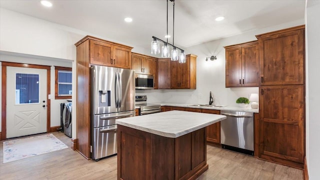 741 Riverside Rd, Holdingford, MN 56340 - kitchen featuring appliances with stainless steel finishes, a sink, washer and clothes dryer, light wood-style flooring, and light countertops