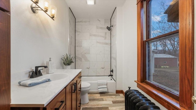 741 Riverside Rd, Holdingford, MN 56340 - full bathroom featuring toilet, vanity, wood finished floors, radiator, and shower / tub combination