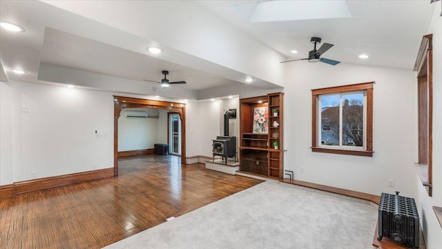 741 Riverside Rd, Holdingford, MN 56340 - living room with ceiling fan, a wood stove, a wall mounted air conditioner, baseboards, and recessed lighting