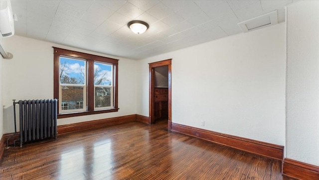 741 Riverside Rd, Holdingford, MN 56340 - spare room featuring radiator heating unit, wood finished floors, baseboards, and attic access