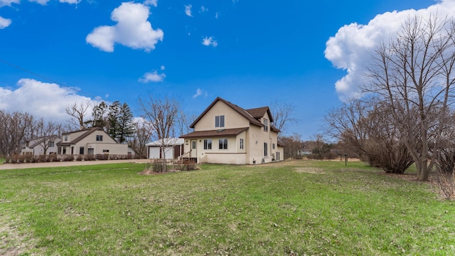 741 Riverside Rd, Holdingford, MN 56340 - back of house with a lawn, stucco siding, and a garage