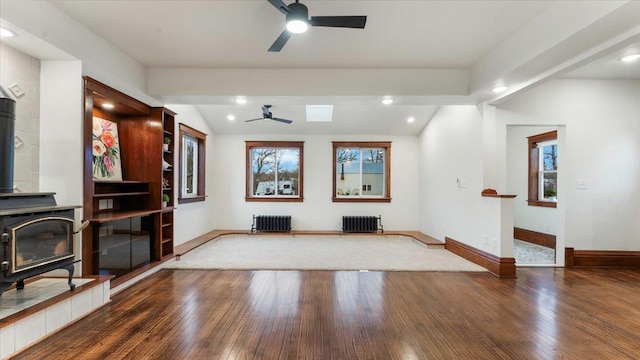 741 Riverside Rd, Holdingford, MN 56340 - unfurnished living room featuring radiator heating unit, a wood stove, a ceiling fan, lofted ceiling, and recessed lighting