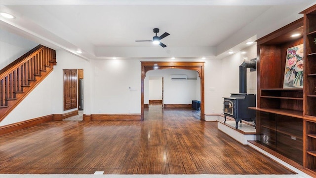741 Riverside Rd, Holdingford, MN 56340 - unfurnished living room featuring hardwood / wood-style floors, a ceiling fan, an AC wall unit, a wood stove, and stairway