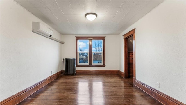 741 Riverside Rd, Holdingford, MN 56340 - spare room featuring radiator heating unit, a wall mounted air conditioner, wood finished floors, and baseboards