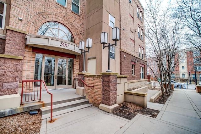 500 2nd St Unit 102, Minneapolis, MN 55401 - view of exterior entry featuring french doors, stone siding, and brick siding