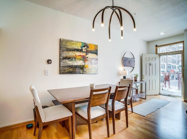 500 2nd St Unit 102, Minneapolis, MN 55401 - dining area with a textured ceiling, a notable chandelier, baseboards, and light wood-type flooring