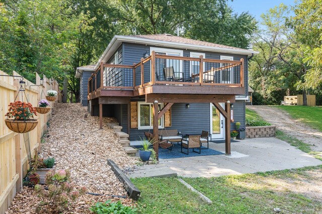 rear view of house featuring fence, a patio, and a deck