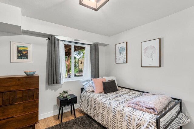 bedroom featuring baseboards and wood finished floors