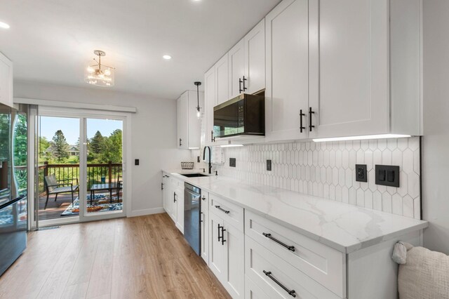 kitchen with light wood-style floors, a chandelier, light stone counters, a sink, and stainless steel appliances