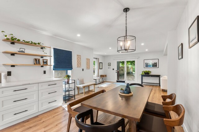 dining space with light wood-type flooring, recessed lighting, and an inviting chandelier