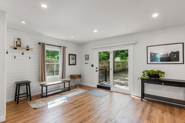 doorway featuring baseboards, plenty of natural light, and light wood-style floors