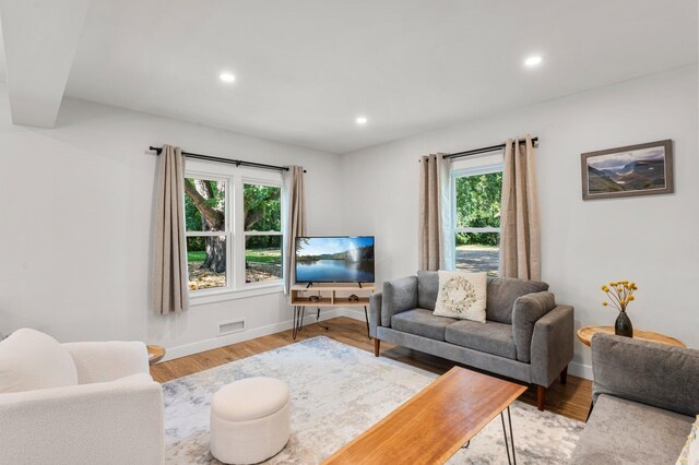 living area with baseboards, light wood-type flooring, recessed lighting, and visible vents