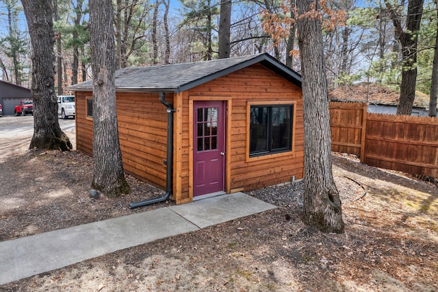 view of outdoor structure featuring an outbuilding and fence