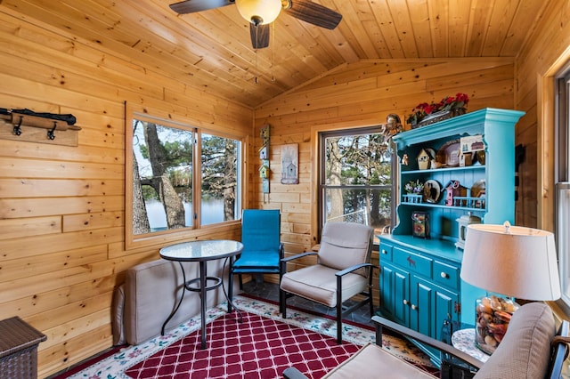 living area with vaulted ceiling, wood walls, and plenty of natural light