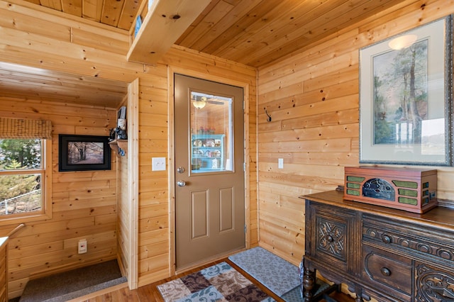 foyer with wood finished floors, wood walls, and wooden ceiling