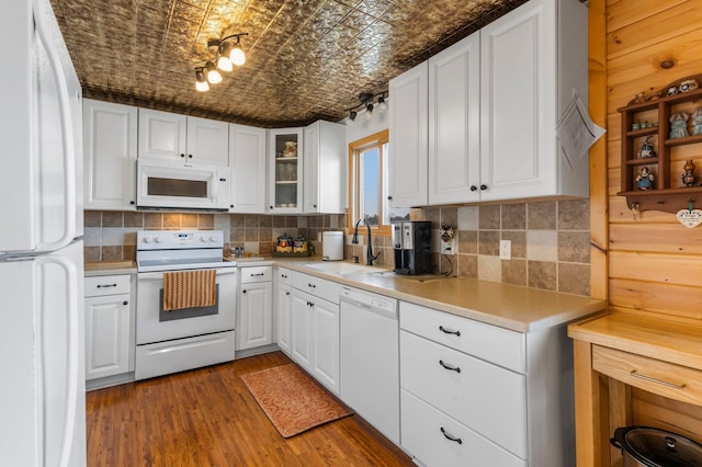 kitchen with white appliances, a sink, backsplash, and an ornate ceiling