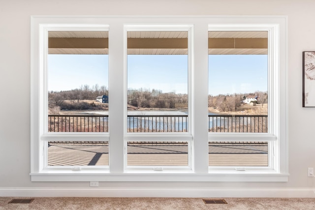 doorway featuring carpet floors, visible vents, and baseboards