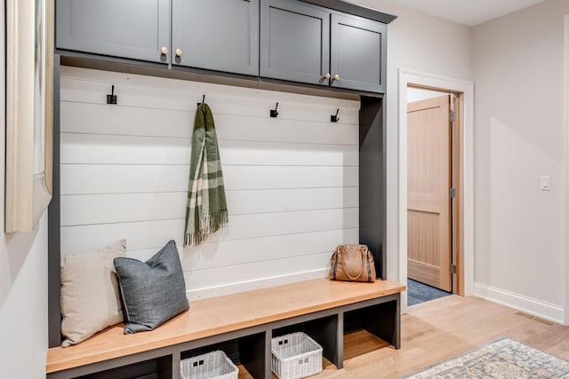 mudroom featuring visible vents, baseboards, and light wood-style floors