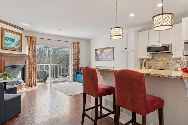 17785 Valley Cove Ct, Minnetonka, MN 55345 - dining space featuring recessed lighting, dark wood-style floors, and a glass covered fireplace