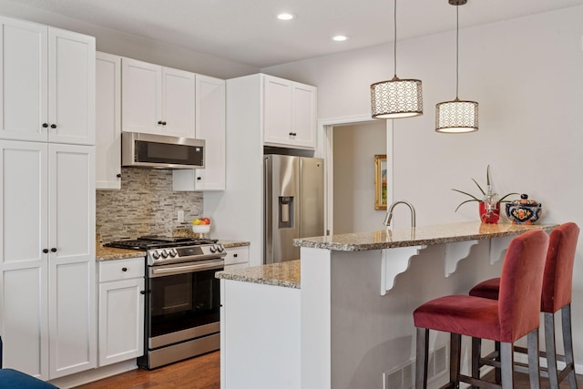 17785 Valley Cove Ct, Minnetonka, MN 55345 - kitchen with stainless steel appliances, light stone countertops, tasteful backsplash, a peninsula, and recessed lighting