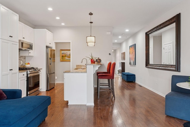 17785 Valley Cove Ct, Minnetonka, MN 55345 - kitchen featuring stainless steel appliances, open floor plan, a kitchen breakfast bar, dark wood-style floors, and recessed lighting