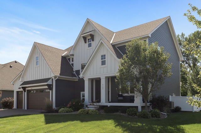 view of front of house with board and batten siding, a front yard, and a shingled roof