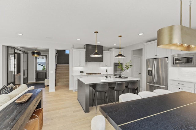 9195 Eagle Ridge Rd, Chanhassen, MN 55317 - kitchen featuring stainless steel appliances, premium range hood, backsplash, a kitchen breakfast bar, and recessed lighting