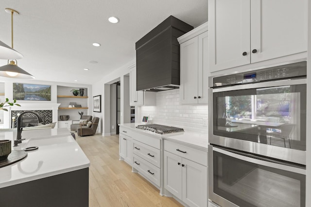 9195 Eagle Ridge Rd, Chanhassen, MN 55317 - kitchen featuring stainless steel appliances, a sink, open floor plan, light wood-style flooring, and light countertops