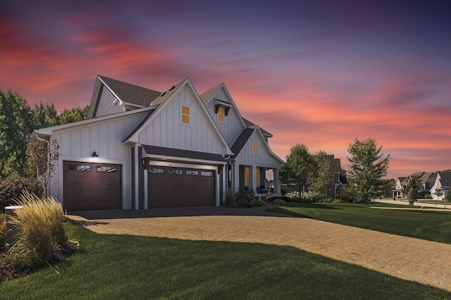 9195 Eagle Ridge Rd, Chanhassen, MN 55317 - modern inspired farmhouse with board and batten siding, an attached garage, a front lawn, decorative driveway, and a shingled roof