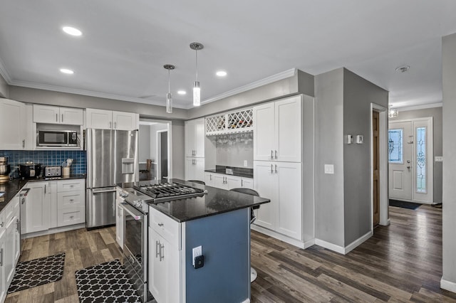 kitchen with crown molding, stainless steel appliances, recessed lighting, white cabinetry, and a kitchen island