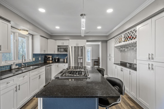 kitchen with a sink, appliances with stainless steel finishes, a breakfast bar area, and a wealth of natural light