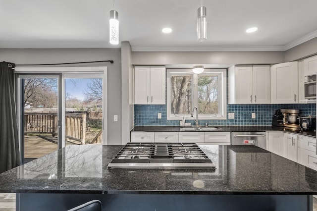 kitchen with a large island, white cabinetry, tasteful backsplash, a sink, and stainless steel appliances