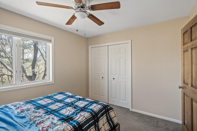 bedroom featuring a closet, ceiling fan, baseboards, and dark colored carpet