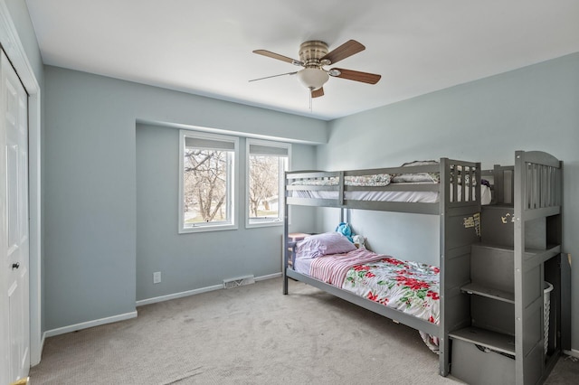 carpeted bedroom with visible vents, baseboards, ceiling fan, and a closet