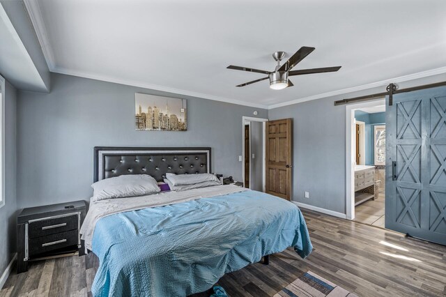 bedroom featuring baseboards, a barn door, crown molding, and wood finished floors